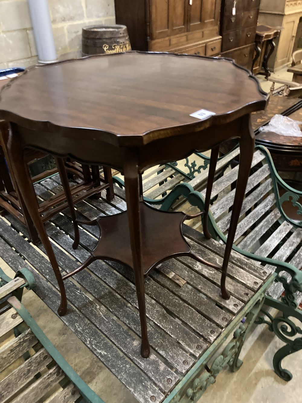 A late Victorian mahogany shaped circular topped two tier table, 67cm diameter, 72cm high